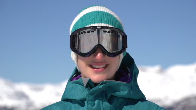 Snowboarder girl puts on ski goggles