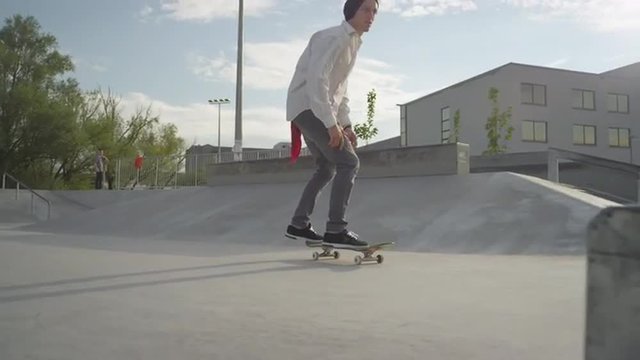 SLOW MOTION: Skateboarder does a flip over the rail in skatepark
