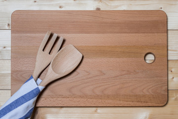 Wooden spatula and fork on the cutting board