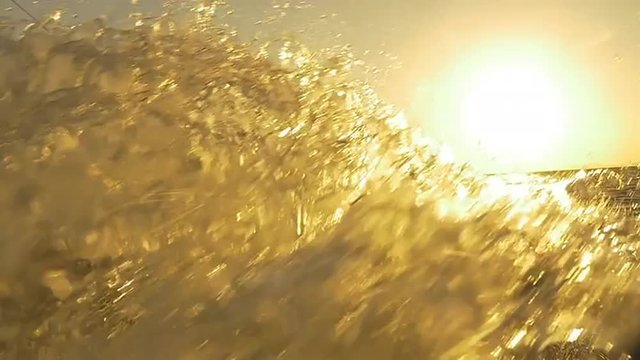 SLOW MOTION: Kiteboarder splashing water into the camera at sunset