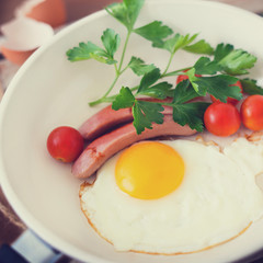 Fried eggs with sausage and tomatoes
