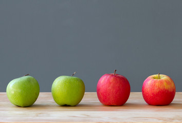 four fresh apples on wood table