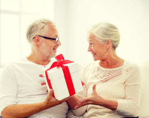 happy senior couple with gift box at home