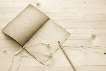 old book,pencil and earphone in vintage style