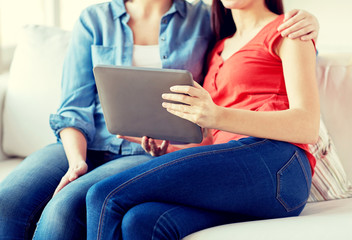 Naklejka premium close up of lesbian couple with tablet pc at home