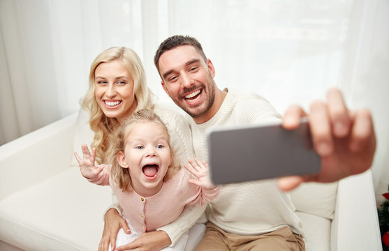family taking selfie with smartphone at home