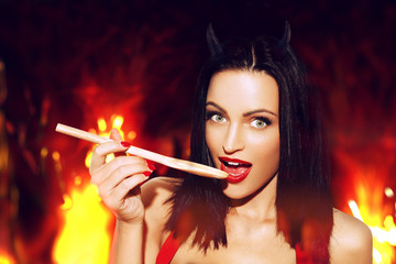 Obraz premium Sexy woman with red lips taste meal in hell