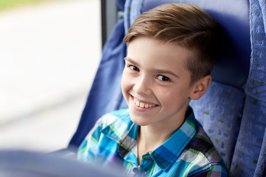 happy boy sitting in travel bus or train