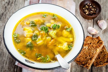 homemade vegetable soup with broccoli, cauliflower, carrots in a bowl