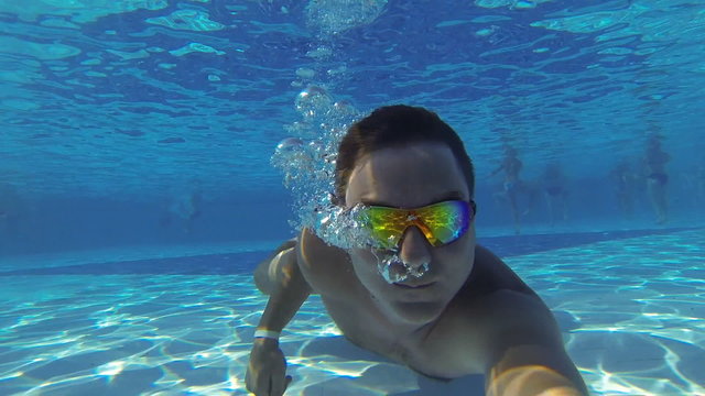 Underwater swimming. Man swims in the pool