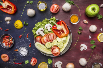 concept cooking vegetarian food sliced cucumbers, tomatoes, onions mushrooms lettuce cucumbers apples in a pan with spices and herbs on wooden rustic background top view close up