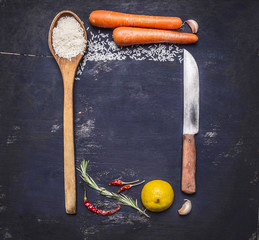 ingredients for cooking rice with vegetables, a knife, a wooden spoon, lemon, spicy, pepper, garlic lined frame with text area on wooden rustic background top view close up