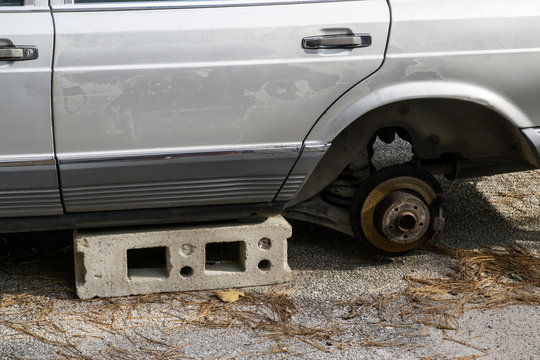Automobile derubata della ruota e lasciata su un mattone