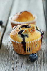 Tasty blueberry muffins on a grey wooden background