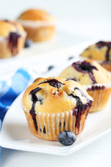 Tasty blueberry muffins on a white wooden background
