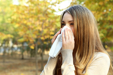Young girl with allergy in autumn park