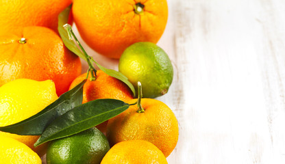 Fresh citrus fruits with leaves on wooden background