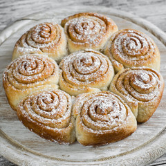 cinnamon rolls on bright wooden surface