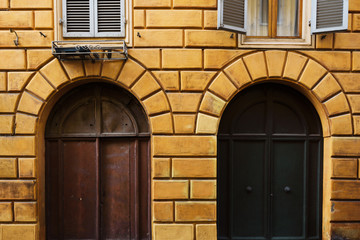 Yellow wall with medieval door in the Tuscan town Siena Italy