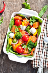 Tasty fried and grilled salmon slices on mixed colorful vegetabl