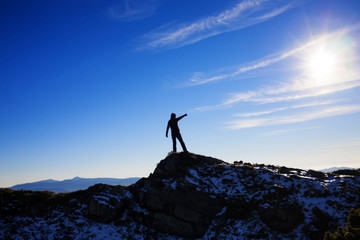 Silhouette of a girl on top of a mountain.