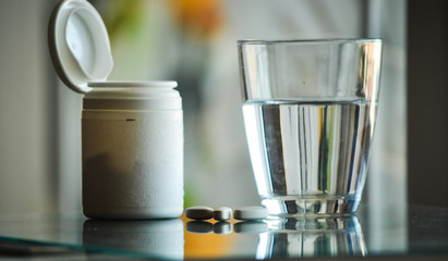 pile of prescription pills with pill bottle in the background