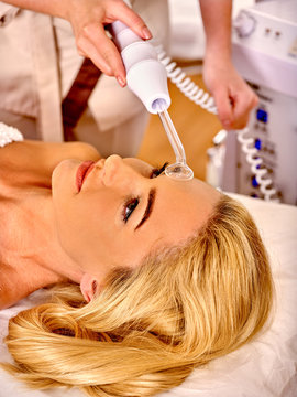 Young woman receiving darsonval facial massage.