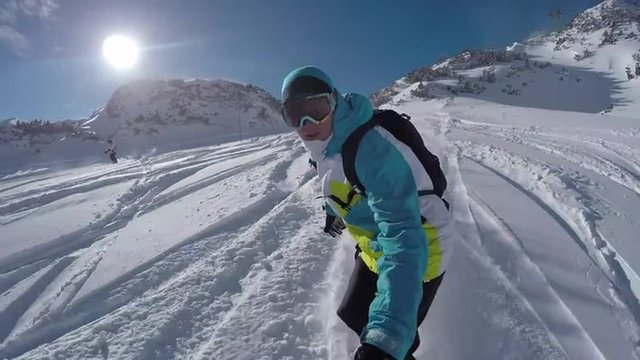 Snowboarder doing powder turns in fresh snow on the mountain