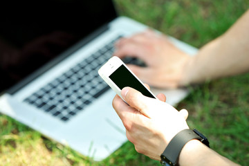 Young man with laptop outdoors