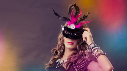 Woman with carnival venetian mask on dark
