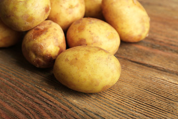Young potatoes on wooden table close up