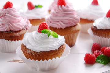 Delicious cupcakes with berries on table close up