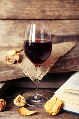 Beautiful composition with glass of wine with old book on table close up