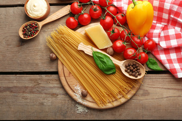 Pasta spaghetti with tomatoes, cheese and basil on rustic wooden  background