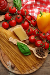 Pasta spaghetti with tomatoes, cheese and basil on rustic wooden  background