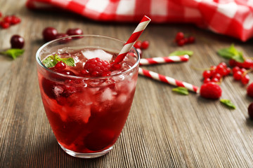 Glass of berry juice on wooden table, closeup