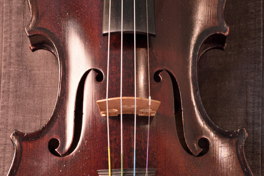 Antique violin closeup against gray fabric background