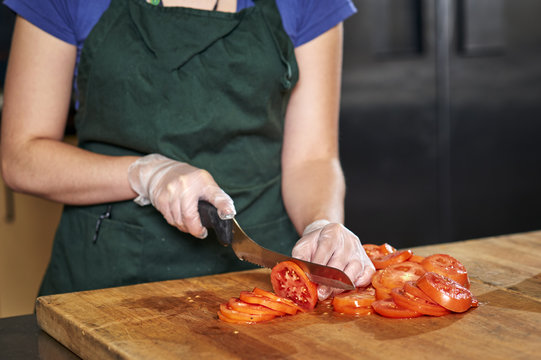 a chef slicing tomatoes