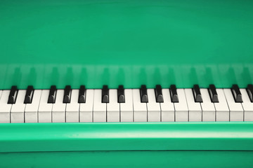 Piano keys of green piano close up