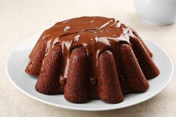 Tasty chocolate muffin with glaze on table close up