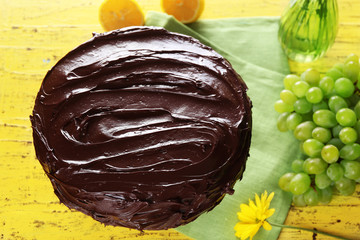 composition of sweet chocolate dessert and fruits on yellow wooden background