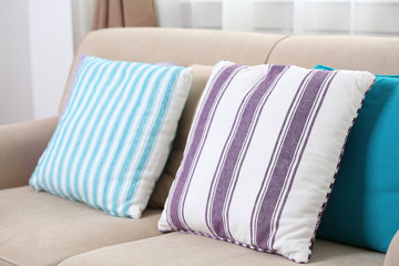 Comfortable sofa with colourful  pillows in the room, close up