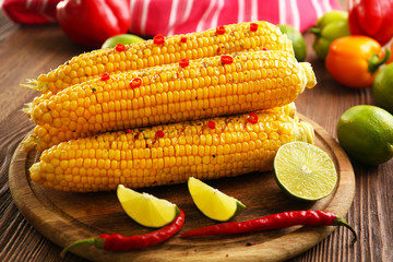 Grilled corn served with vegetables on rustic round plate