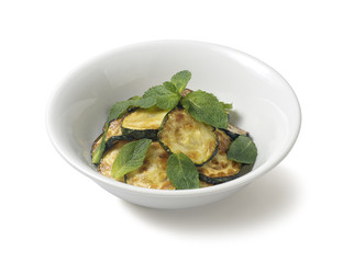 Sauteed zucchini with mint leaf on a white background