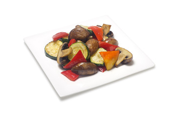 Sauteed zucchini with mushrooms, bell pepper on a white background