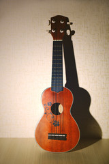 Fototapeta premium Beautiful Hawaiian acoustic guitar on light wallpaper background