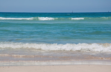 Fresh green waves on Es Trenc beach on a sunny summer day in July in Mallorca, Balearic islands, Spain.