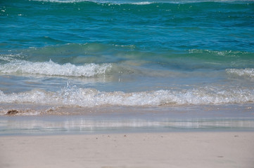 Fresh green waves on Es Trenc beach on a sunny summer day in July in Mallorca, Balearic islands, Spain.