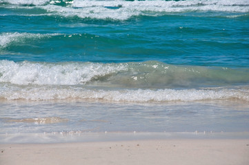 Fototapeta na wymiar Fresh green waves on Es Trenc beach on a sunny summer day in July in Mallorca, Balearic islands, Spain.