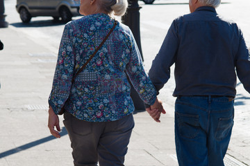 elderly couple holding hands